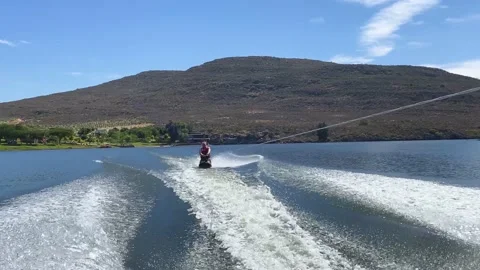 Man kneeboarding behind speed boat on Bulshoek Dam, South Africa Stock Footage 181490760