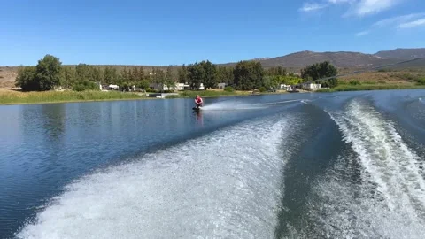 Man kneeboarding swerving out of speed boat wake on Bulshoek Dam, South Afric 스톡 동영상 181487633