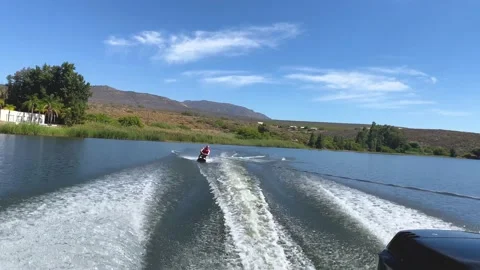 Man kneeboarding swerving side to side in speed boat wake on Bulshoek Dam, So Stock Footage 181487800