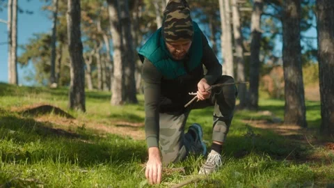 Man is kneeling in the grass and looking for something Video stock 331813565