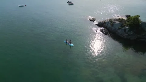 Man Kneeling On Surfboard While Paddling In The Clear Water Stock Footage 249726647