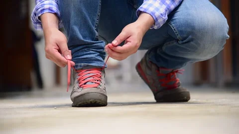 Man kneels down rope tie shoes industry boots for worker. Close up shot of man h Stock Footage 268768288
