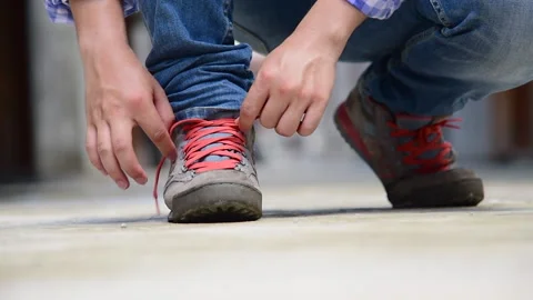 Man kneels down rope tie shoes industry boots for worker. Vídeo Stock 271216867