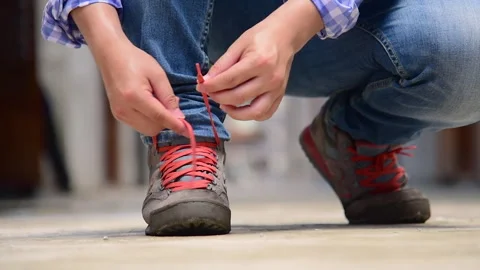 Man kneels down rope tie shoes industry boots for worker. Stock Footage 271216970