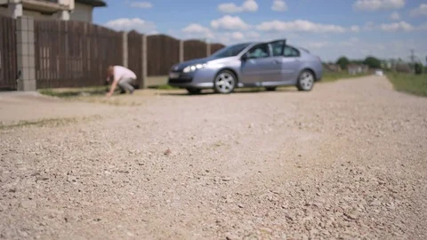 A man on the knees trying to open a driveway wooden gates Video stock 82740959