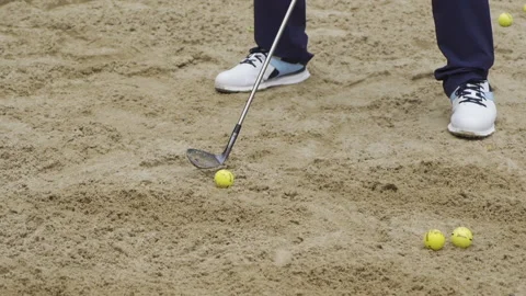 A man knocks the ball out of a sand trap Video stock 155380258