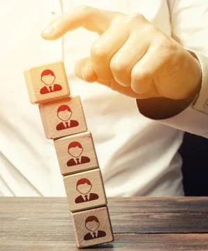Man knocks down a tower of blocks with employees. Mass layoffs, closing a bus Stock Photos