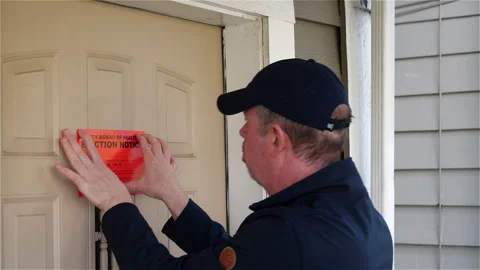 Man knocks on the front door of a residence and delivers eviction notice Stock Footage 144519448