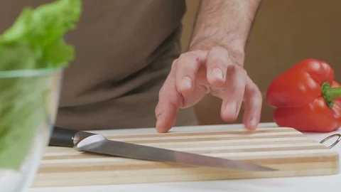 A man knocks his fingers on the cutting board in the kitchen, pondering the Stock Footage 101798898