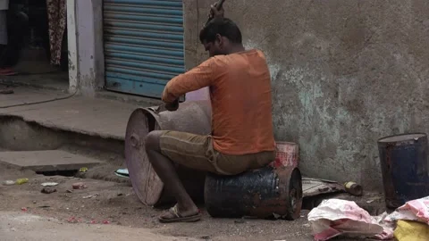 Man Knocks to open a barrel for recycling, India Market Stock Footage 205615009