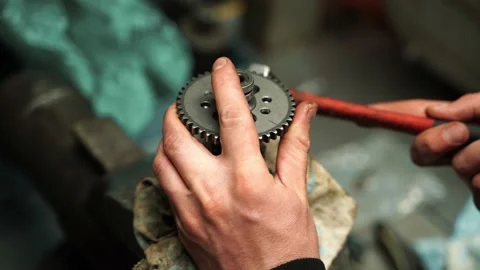 A man knocks a star off the shaft from the engine valve block with a hammer Vidéo 156034916