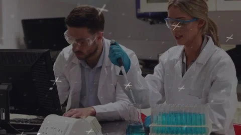 Man at lab computer typing while woman lifting pipette and transferring blue Stock Footage 330337346