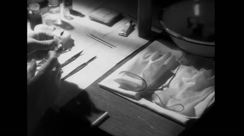 Man in lab picking up needle and scalpel from table filled with surgical tools Vídeos de archivo 58858530