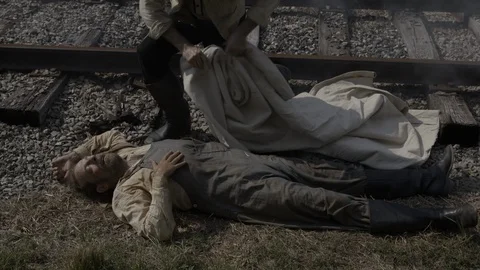 Man, laborer lying dead next to RailRoad tracks - 1800s Western Portrayal Video stock 103815102