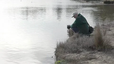 Man by a lake Stock Footage 1058105