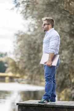 Man at the lake with notebook Stock Photos