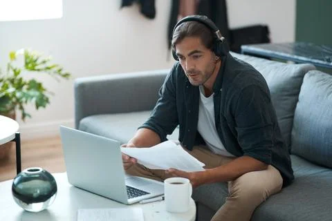 Man, laptop and documents with remote work from home with headphones, admin.. Foto stock