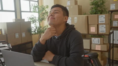 Man with laptop and parcels touching neck and resting chin on fist in build.. Stock Footage 337353958