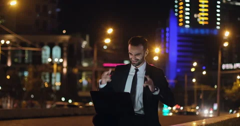A man with laptop, backdrop of the evening city lights Stockbeeldmateriaal 150656360