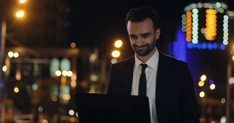 A man with laptop, backdrop of the evening city lights Stock Footage 150660446