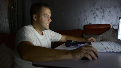 Man with laptop, chips and beer at home in the evening. Watching movie or online Видео 96014557