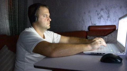 Man with laptop, chips and beer at home in the evening. Watching movie or online Видео 96014655