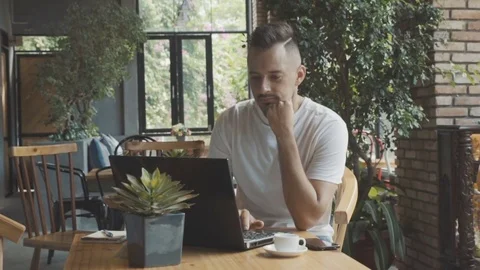 Man with laptop computer planning new business at cafe. Young businessman. Stock Footage 76492276
