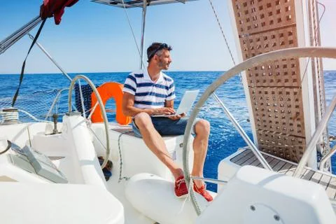Man with laptop computer on sailboat Foto stock