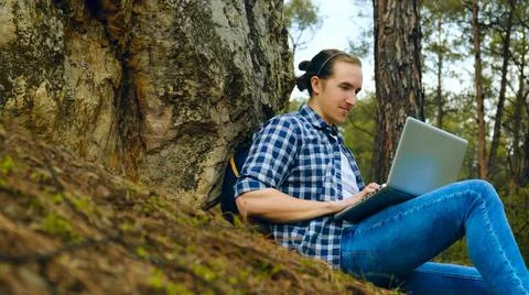 Man with laptop in forest. Stock Photos