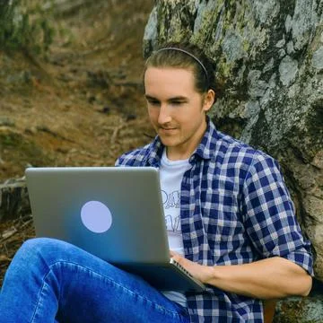 Man with laptop in forest. Stock Photos