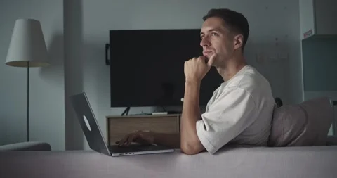 Man with laptop managing remote tasks, laptop enabling flexible schedule from Stock Footage 312122422