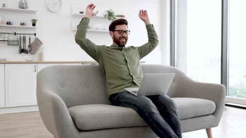 Man with laptop resting on couch during remote work Stock Footage 253373293
