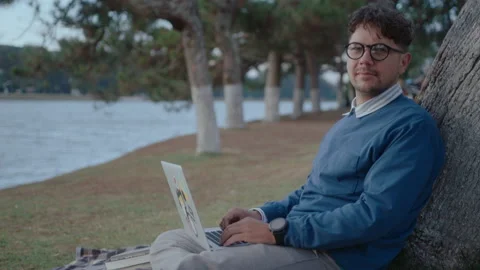 Man with Laptop Sitting by Tree Posing on Camera Stock Footage 237058801