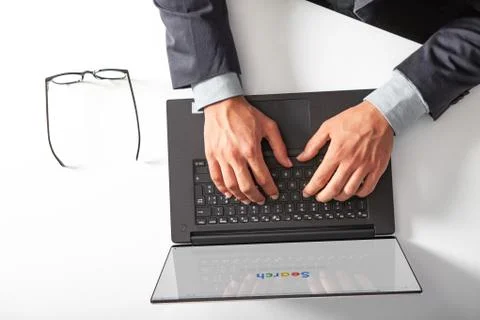 Man with laptop typing on the keyboard doing a search. Stock Photos