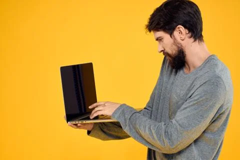 Man with laptop wireless technology internet lifestyle work yellow isolated Stock Photos