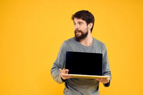 Man with laptop wireless technology internet lifestyle work yellow isolated Stock Photos