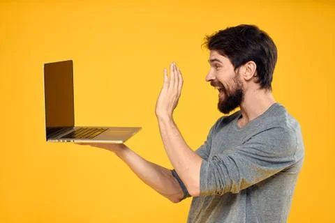 Man with laptop wireless technology internet lifestyle work yellow isolated Stock Photos