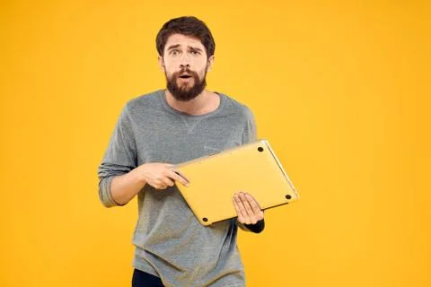 Man with laptop wireless technology internet lifestyle work yellow isolated Stock Photos