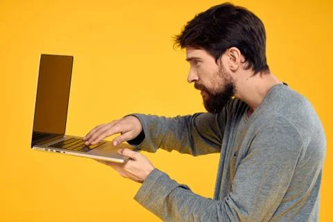Man with laptop wireless technology internet lifestyle work yellow isolated Stock Photos