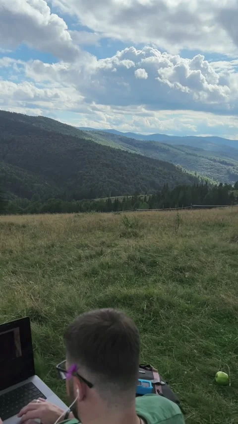 Man with laptop working outside on the top of the mountain Stock Footage 253384898