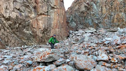 Man with a large backpack and trekking poles walks in the mountains Vídeos de archivo 249149470