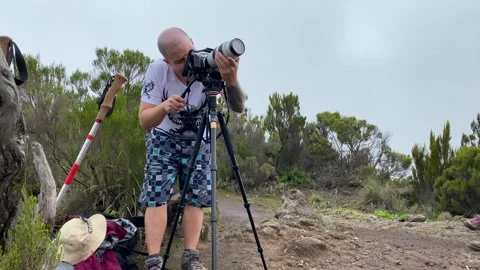 Man with a large camera on a tripod takes pictures of the nature of Africa Video stock 168861386