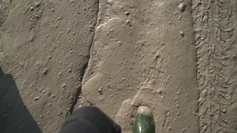 A man in large dirty rubber boots is standing in a dirty spring puddle Stock Footage 152774683