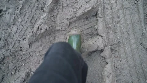A man in large dirty rubber boots is standing in a dirty spring puddle Stock Footage 152774855