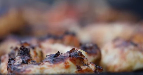 A man with a large fork removes grilled chicken wings from the grill Stock Footage 117883722