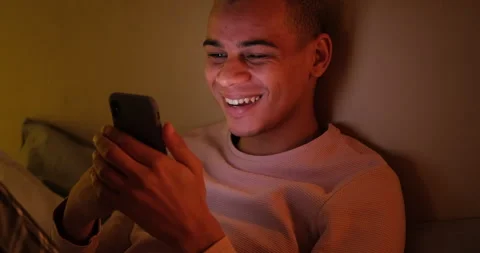 Man laughing and using mobile phone late night Stock Footage 145292671