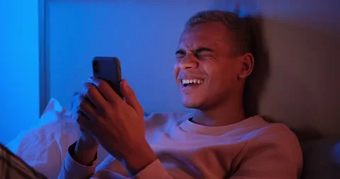 Man laughing using mobile phone late night Stock Footage 145292183
