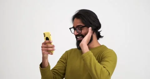 Man laughing while talking over video call on smartphone Stock Footage 239453416