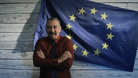 A man laughs at the background of the EU flag Stock Footage 95317659