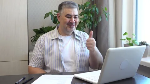 A man laughs during a video call via computer Stock Footage 273788428